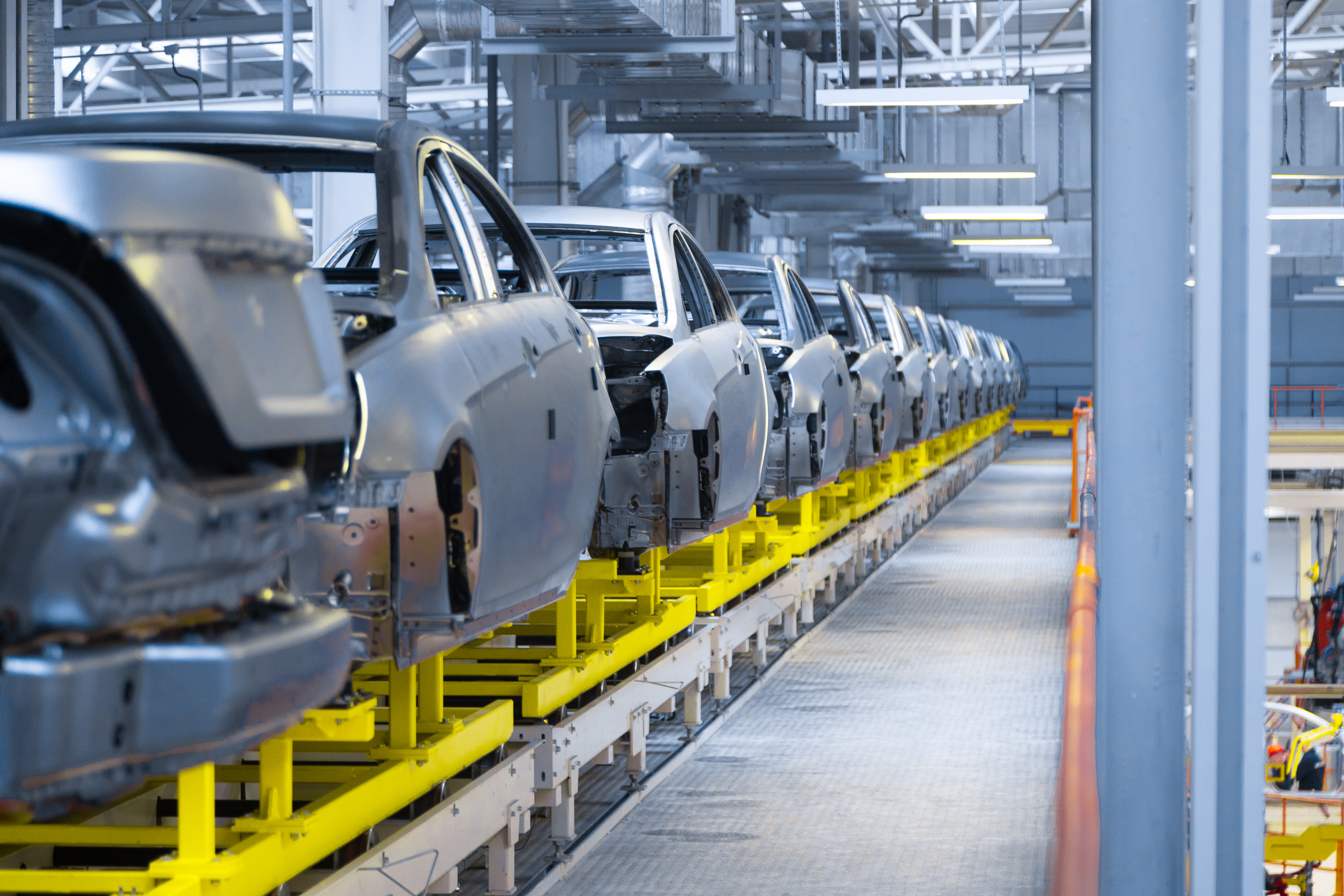 Inside the SAGLEV electric vehicle assembly factory with vehicles lined up on the production line
